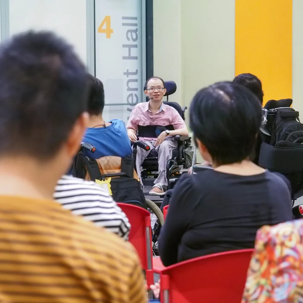 Boon Keng speaking to a crowd of people at an event.