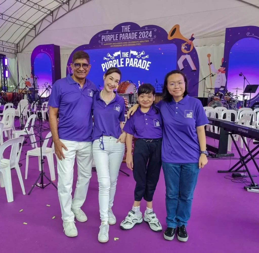 Pearl standing with friends, all wearing the Purple Parade 2024 t-shirts and bright smiles on their faces.