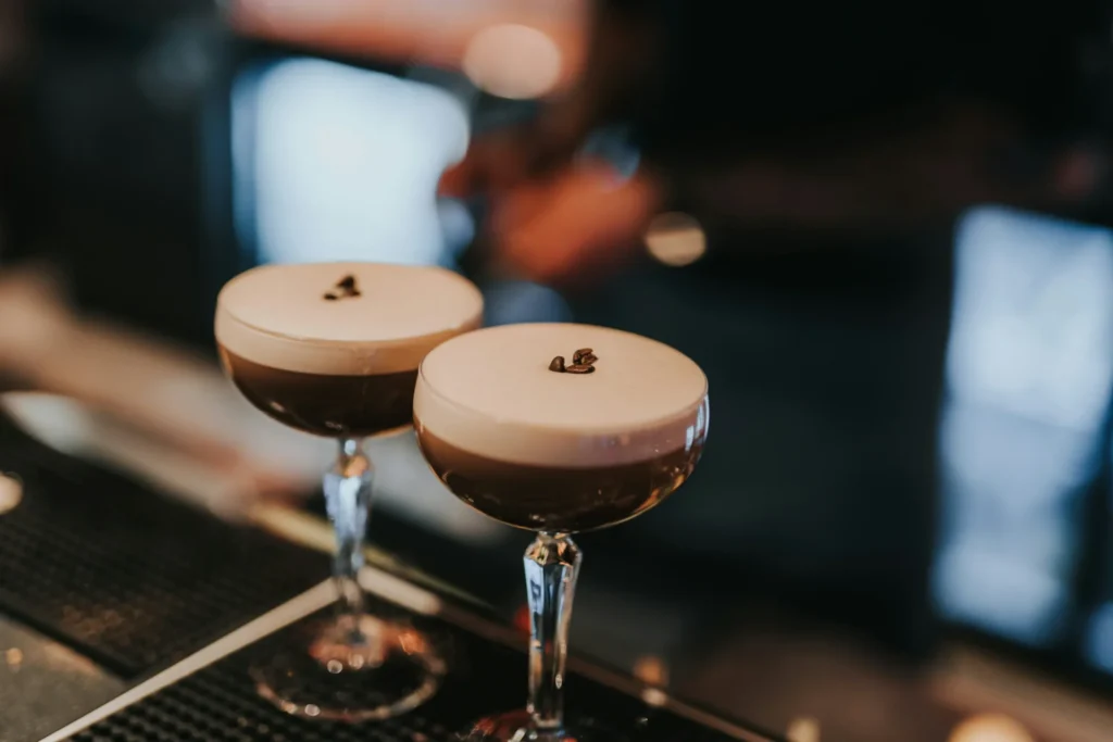 An image of two espresso martinis on a bar countertop. The drink is dark and has creamy foam that is topped with a few coffee beans. A picture of an espresso martini. Mixology is another one of Winston’s interests in the kitchen.