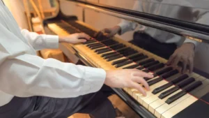 Closeup of Azariah’s hands as he plays the piano.